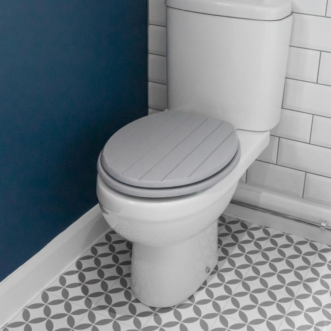 Grey soft-close tongue and groove MDF wood toilet seat showing seat in place on a white ceramic toilet